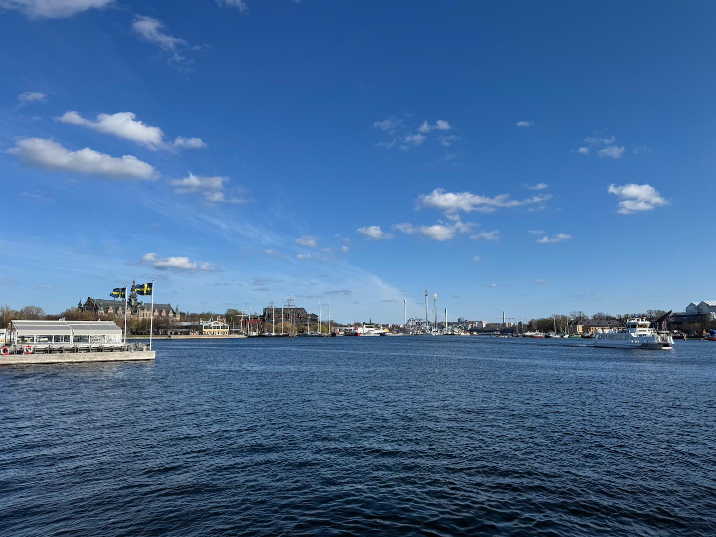 Waterfront city view along Strandvägen boulevard in Stockholm featuring historic buildings and moored boats.
