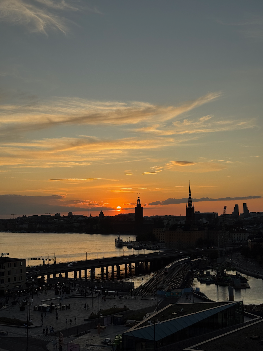 Historic buildings of Gamla Stan in Stockholm illuminated by warm sunset light over the water.