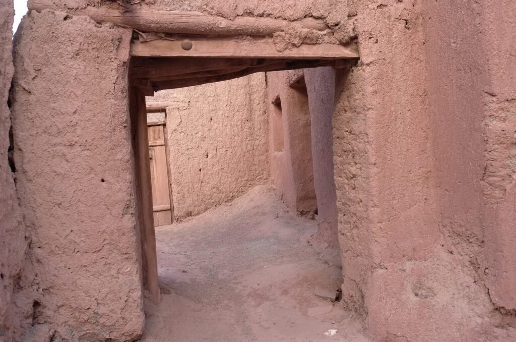 Covered alley between red mud walls in Abyaneh