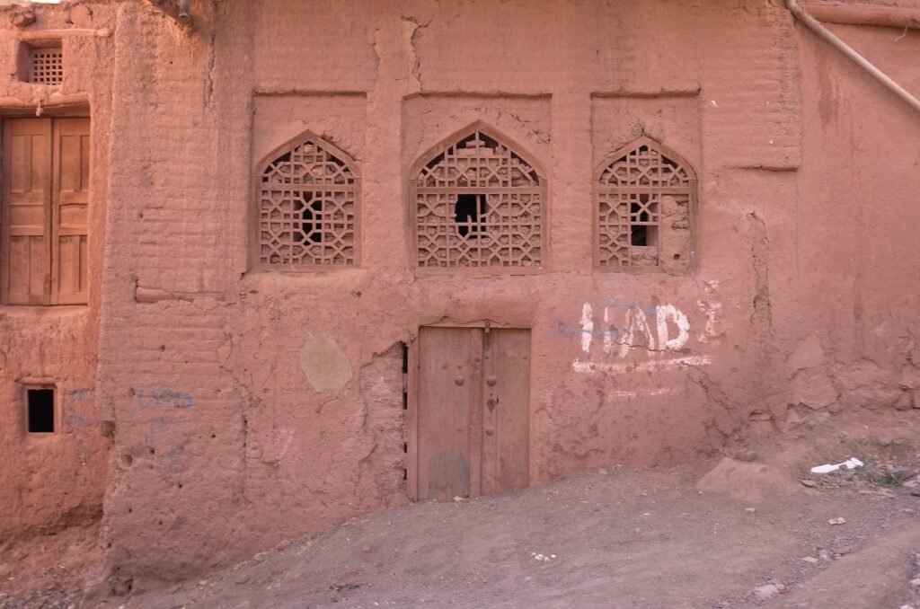 Red house with carved wooden windows in Abyaneh