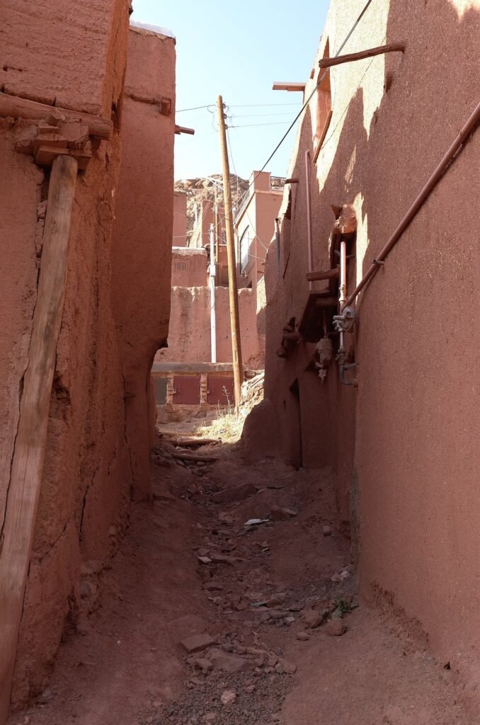 Narrow lane between red mud houses in Abyaneh