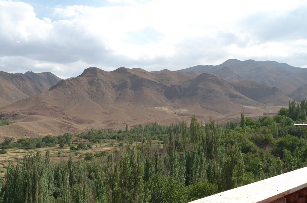 Green valley with poplar trees below dry mountains near Abyaneh