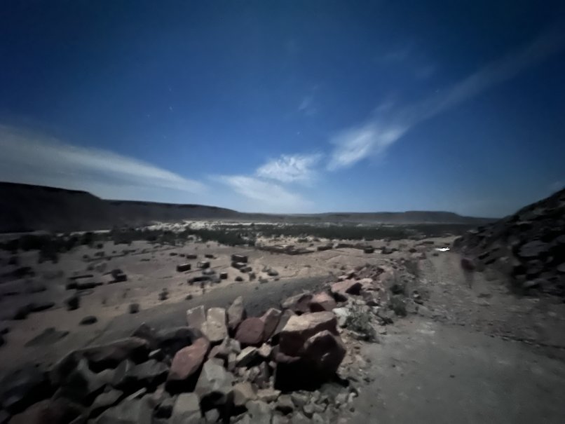 Rocks lie in a dry valley under a night sky in the Adrar region.