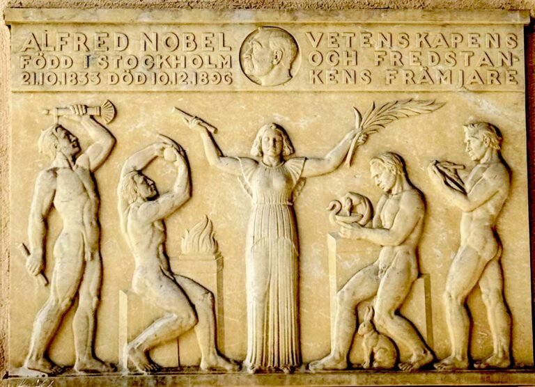 Stone relief in memory of Alfred Nobel, with his name, the years 1833 and 1896 and carved figures