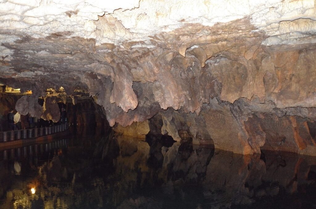 Low cave ceiling over dark water in Ali Sadr Cave