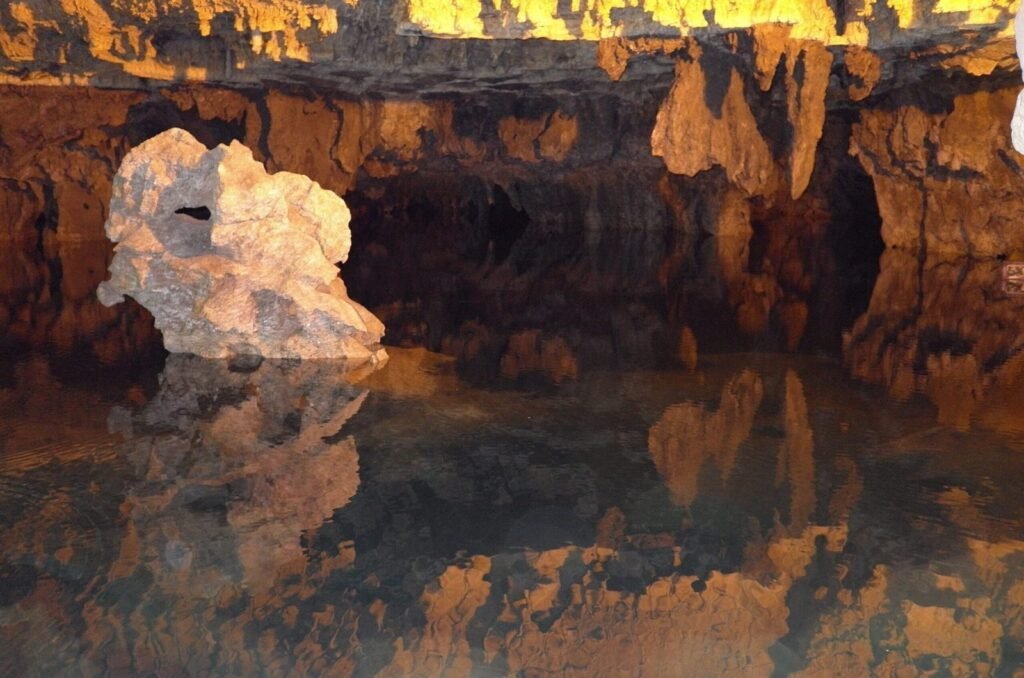 Rock formations reflected in the water of Ali Sadr Cave