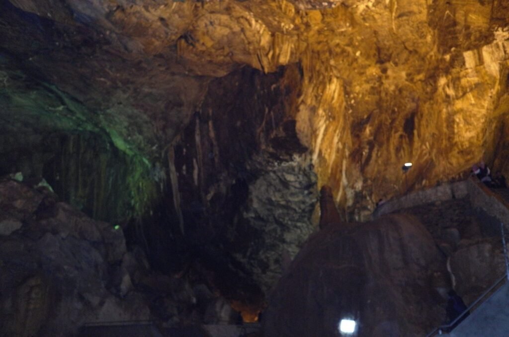 Dark cave passage with orange light in Ali Sadr Cave