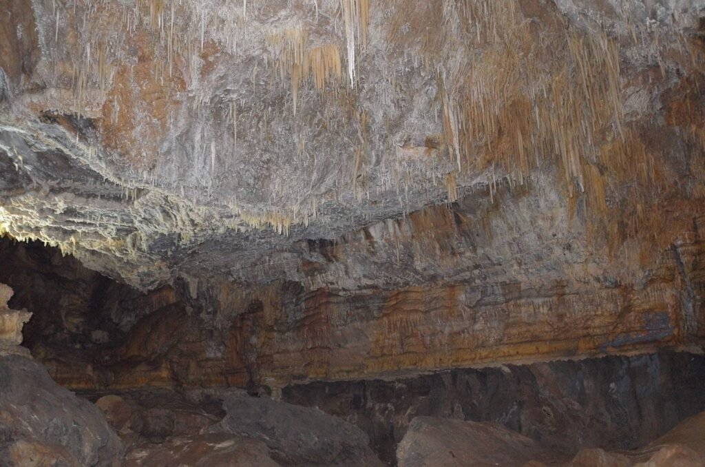 Layered rock wall above the water in Ali Sadr Cave