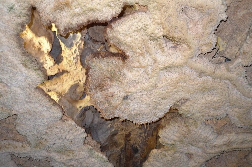 White and yellow rock formations on the cave ceiling