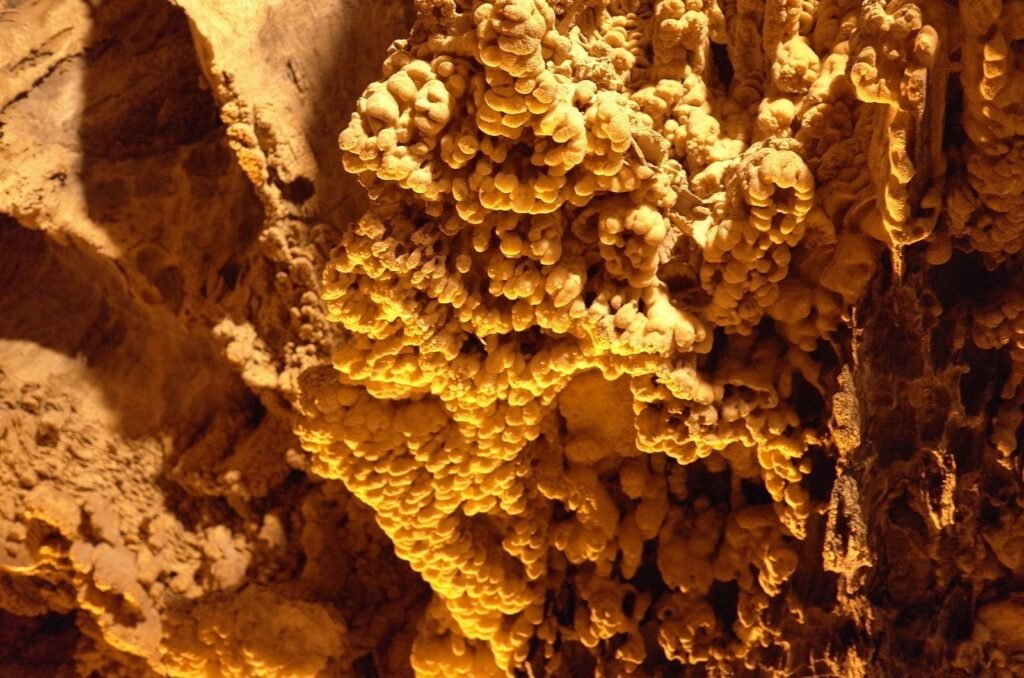 Golden lit rock formations in Ali Sadr Cave