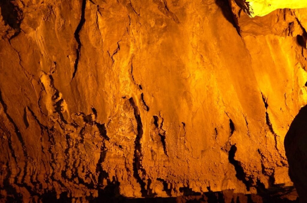 Orange lit rock wall in Ali Sadr Cave