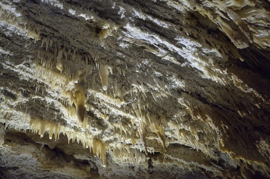 Grey and white stalactites on the cave ceiling