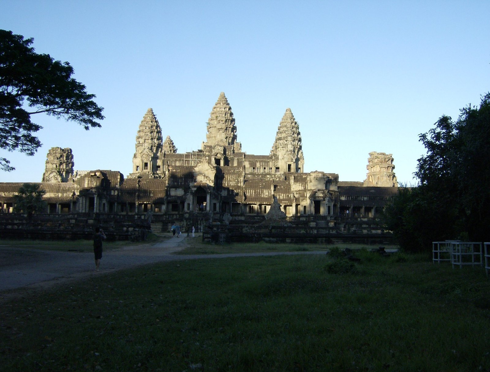 Angkor Wat temple with its five towers stands behind a green lawn near Siem Reap.