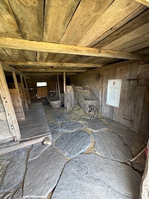 Old farm building at Askhult with a stone slab floor, wooden walls and a cart