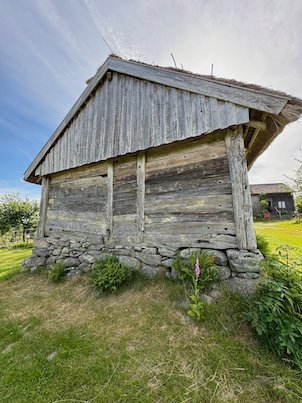 Old grey wooden storehouse on a stone foundation at Askhult
