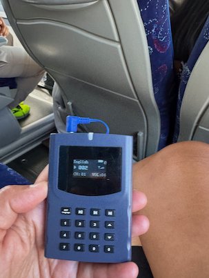 Audio guide device with buttons held in a hand on the tour bus to Meteora