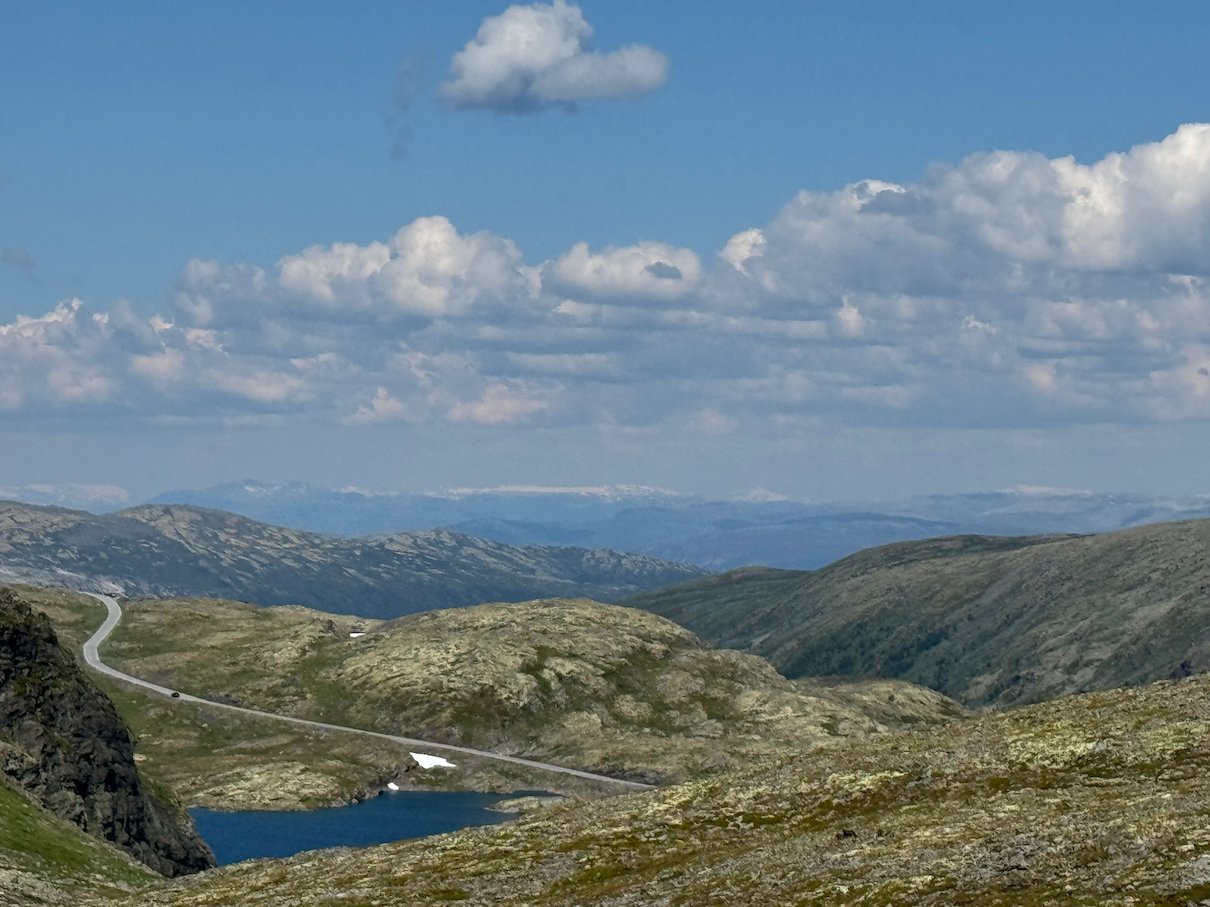 The Aurlandsfjellet road that winds down into a valley with a small lake