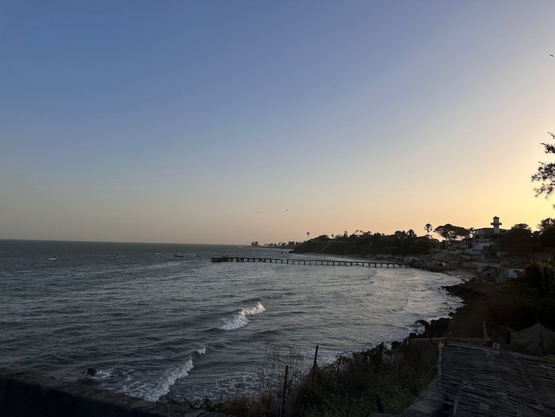 Waves roll onto the rocky coast at dusk near Bakau on the Atlantic coast of The Gambia.