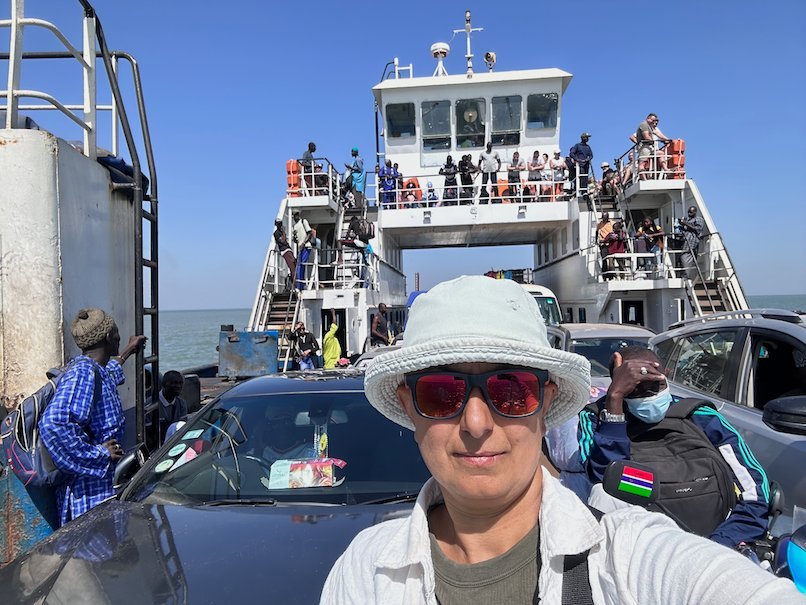 Zayera Khan takes a selfie in a sun hat on the car deck of the Banjul ferry.