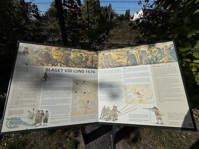 Open illustrated panel Slaget vid Lund 1676, with drawings of soldiers and a map of the battle