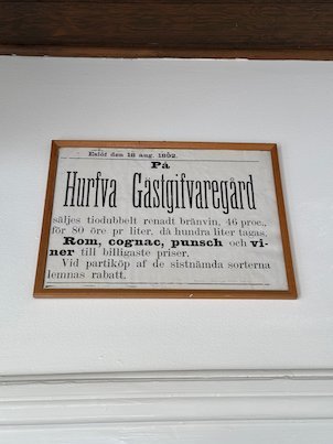 Old framed advert for Hurfva Gästgifvaregård, offering brännvin, rum, cognac and punsch at low prices