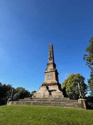 Wide view of the Battle of Lund obelisk on its grass hill in Monumentsparken