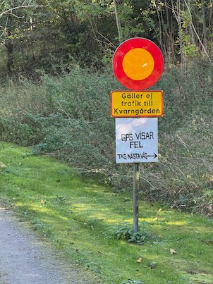 No entry road sign with the text Gäller ej trafik till Kvarngården and a hand-written sign GPS visar fel