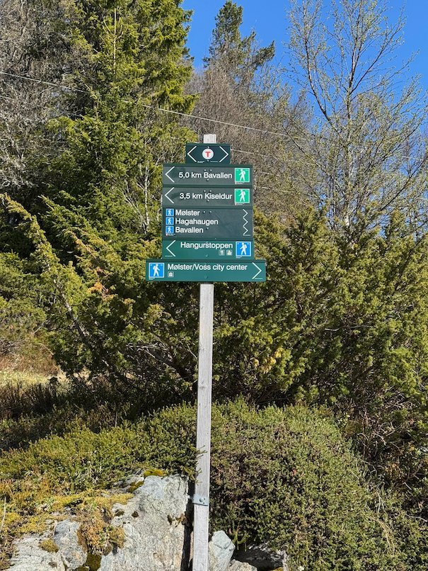 Signpost with distances to Bavallen, Kiselbotn and Hangurstoppen, among juniper and birch