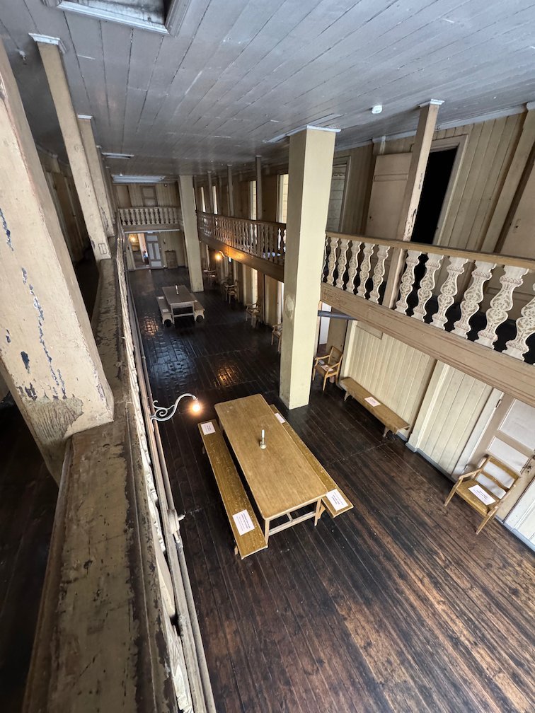 Wooden hall with a gallery and long tables inside St. Jørgen’s Hospital, the Leprosy Museum in Bergen