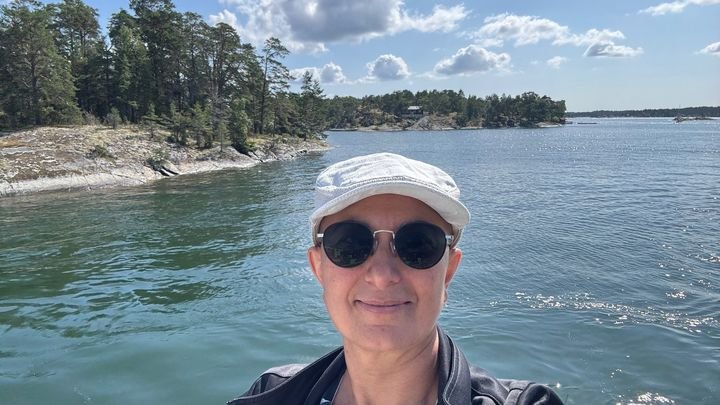 Zayera Khan on a boat tour in the Stockholm archipelago, with islands behind her, photographed by Zayera Khan