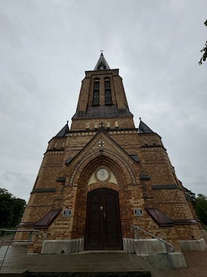Front of a tall brick church in Borås under a grey sky