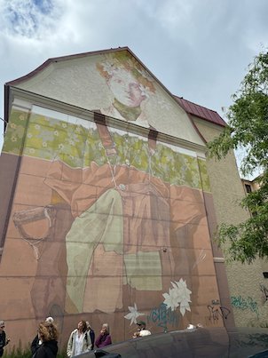 Large mural of a woman on the gable of a building in Borås