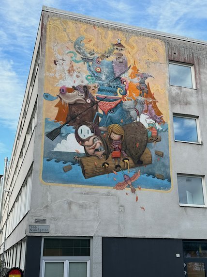 Colourful street art mural with fantasy figures on a white building in Borås