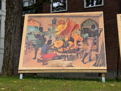 Painted panel with people and large orange mushrooms in front of a brick building