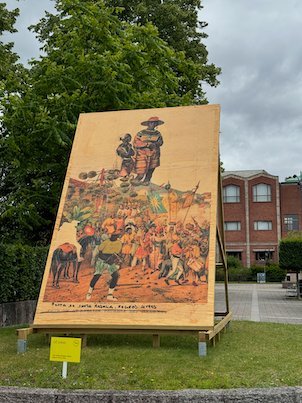 Large painted panel with a rider and people, set up on a lawn
