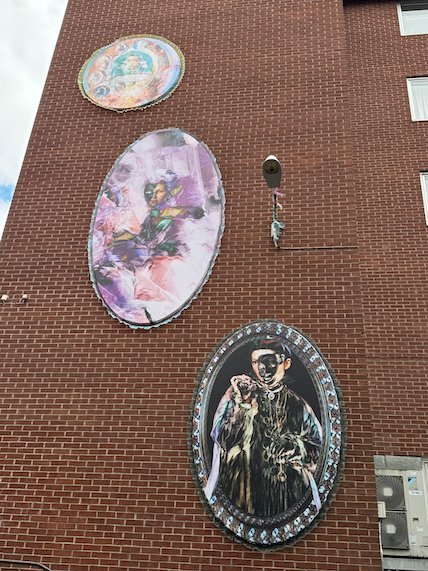 Three round murals on a red brick tower in Borås