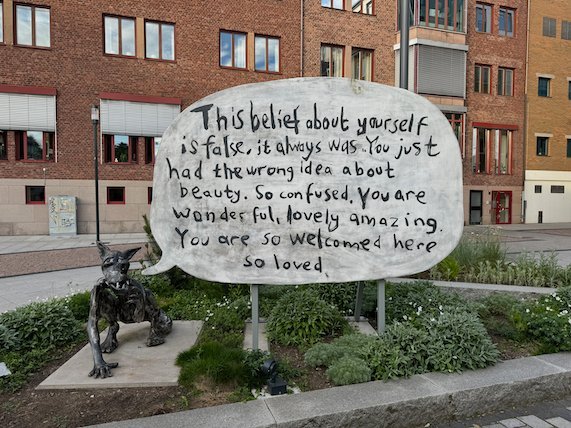 Wolf sculpture Vargen by Nathalie Djurberg and Hans Berg, with a big speech bubble of kind words