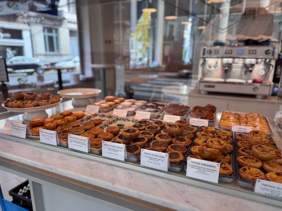 Many pastries lie on a counter in a bakery in Brussels.