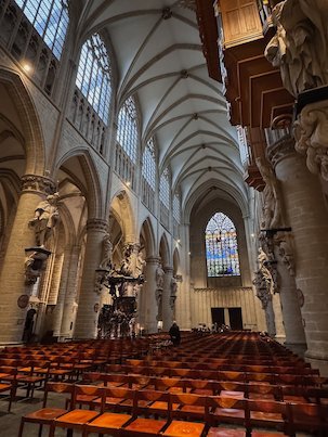 Rows of wooden chairs fill the Gothic nave of the cathedral in Brussels.