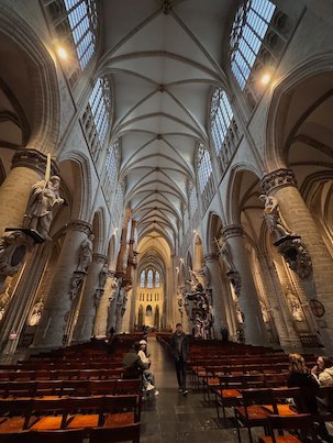 Statues stand on the pillars of the long nave of the cathedral in Brussels.