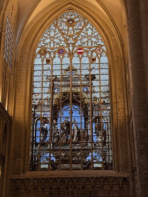 A tall stained glass window fills a wall of the Cathedral of St. Michael and St. Gudula.