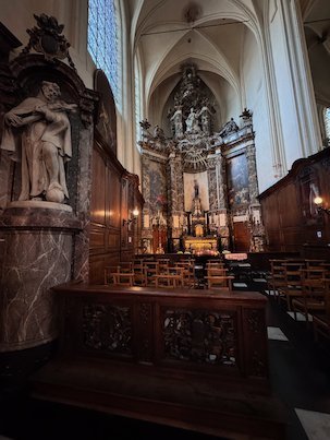 A baroque altar and carved wood fill the choir of a church in Brussels.
