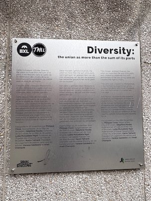 A metal plaque with the title Diversity hangs on a wall in Brussels.
