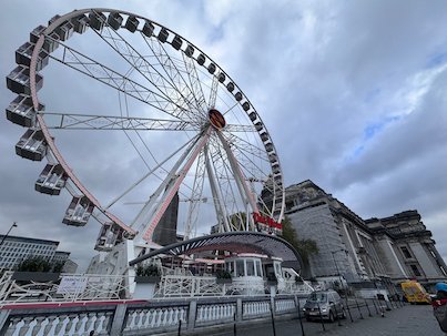 A Ferris wheel turns next to the Palace of Justice in Brussels.