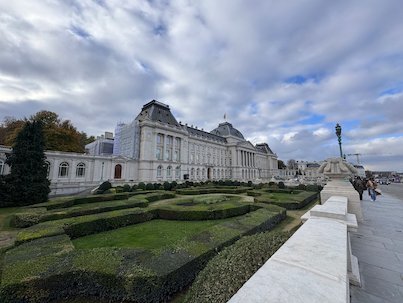 A formal garden with low hedges lies in front of a palace building in Brussels.