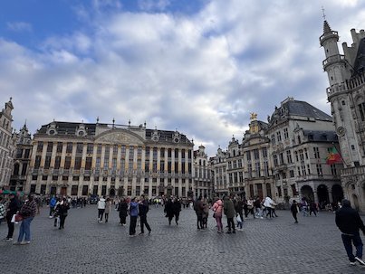 Visitors walk across the wide Grand-Place with its historic buildings in Brussels.