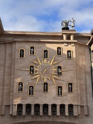 A large clock with small statues decorates a building at the Mont des Arts in Brussels.
