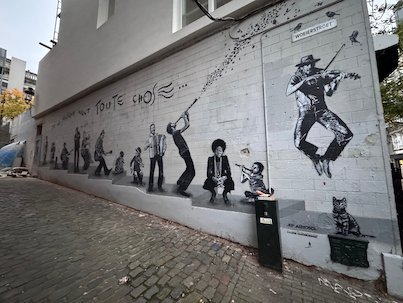 A long black and white mural of musicians covers a wall in Brussels.