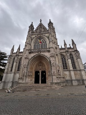 The Gothic facade of Notre-Dame du Sablon church rises above wide steps in Brussels.