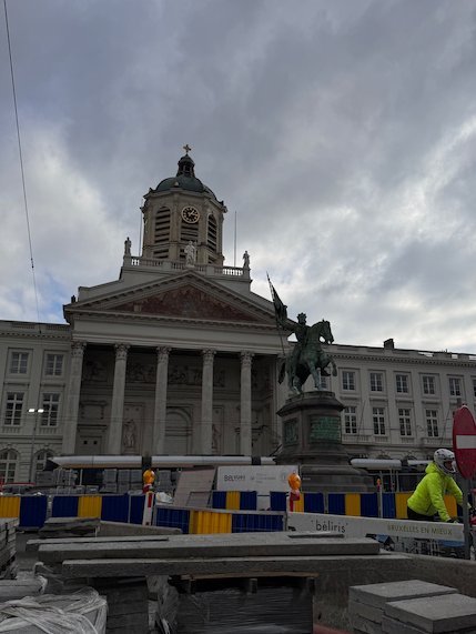 A church with columns and a rider statue stand on the Place Royale in Brussels.
